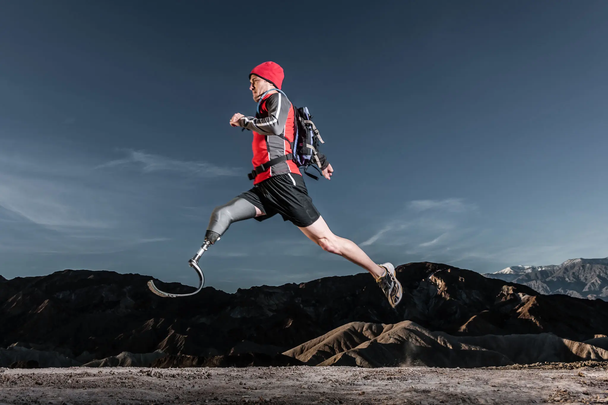 Athlete with prosthetic legs running outdoors.